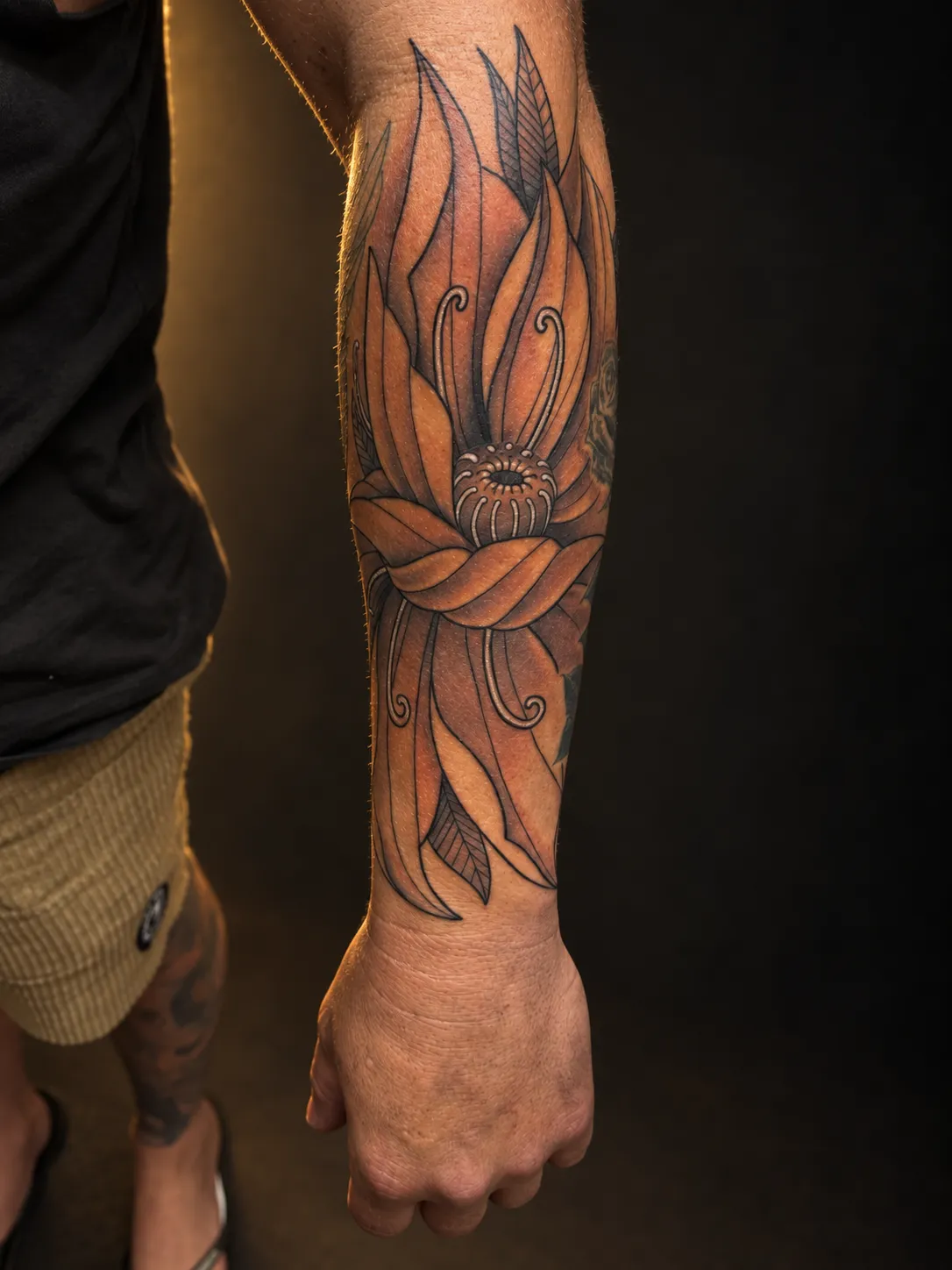 Black and grey flower tattoo on the forearm